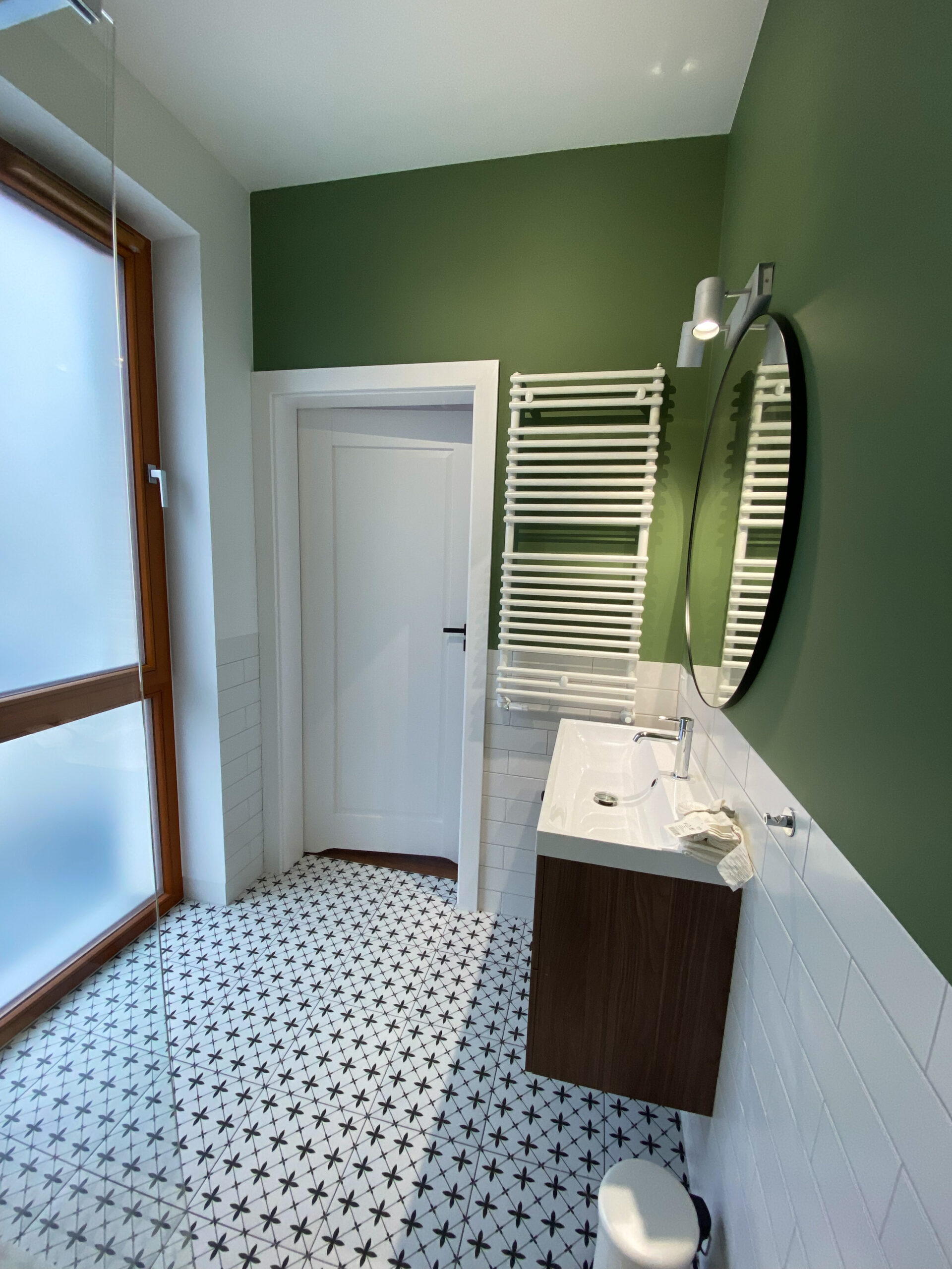 łazienka z prysznicem, płytki białe cegiełki tamoe, okrągłe lusto. zielona ściana
